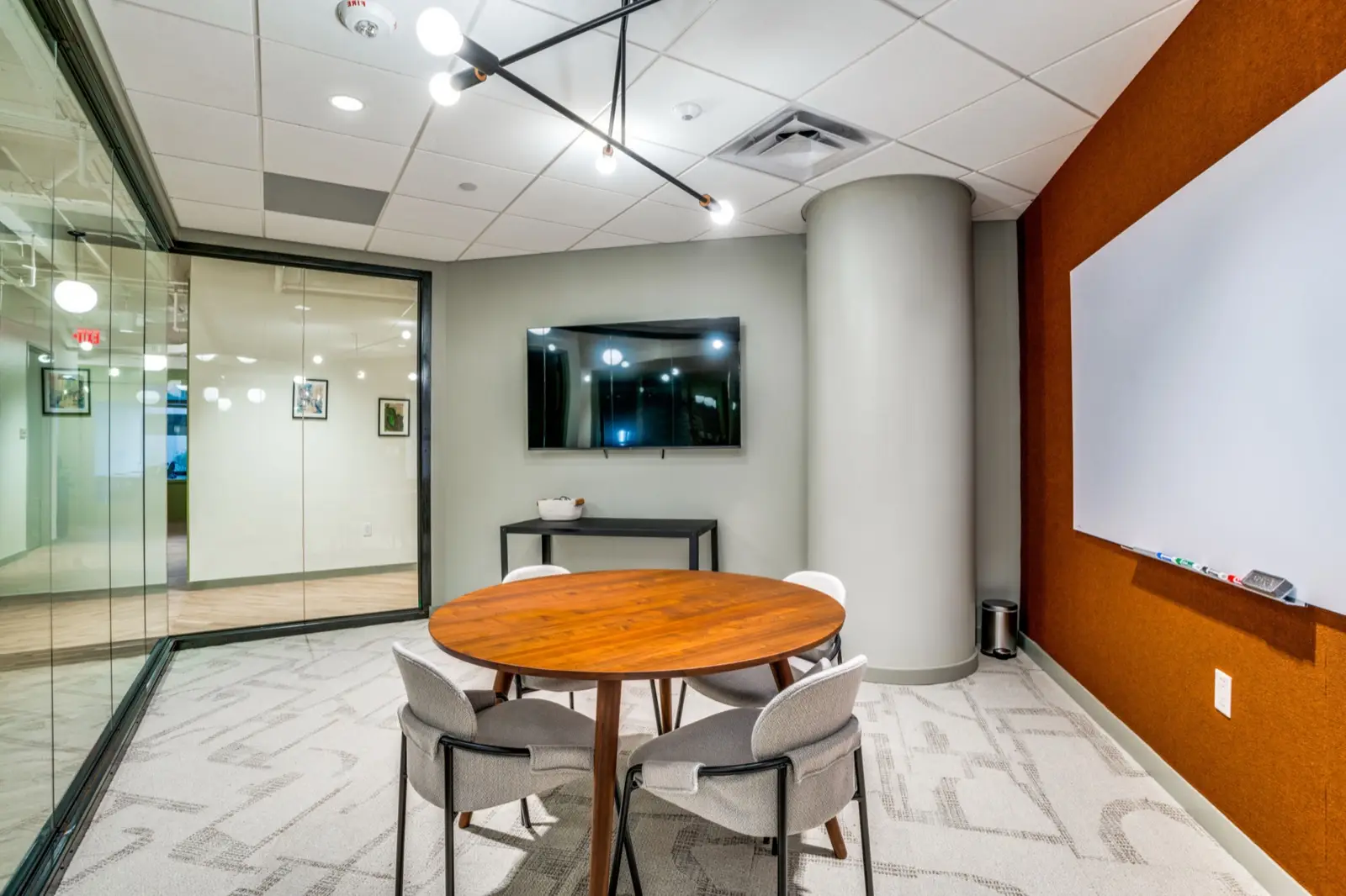Round meeting room with an orange accent wall and whiteboard